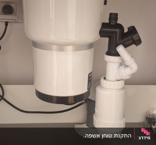מתקן אינסטלציה מתחת לכיור עם צינורות וחיבורים